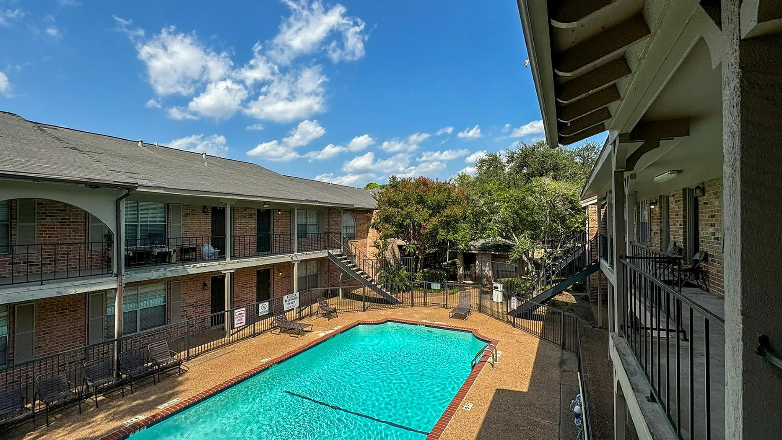 Courtyard pool with brick coping, lounge chairs and two-story balconies, Memorial City, Houston TX