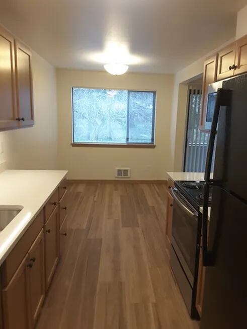Inviting kitchen with modern appliances, sleek wooden cabinets, and natural light streaming through a large window.