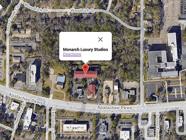 Aerial view highlighting Monarch Luxury Studios surrounded by lush greenery and urban amenities on Apalachee Parkway.