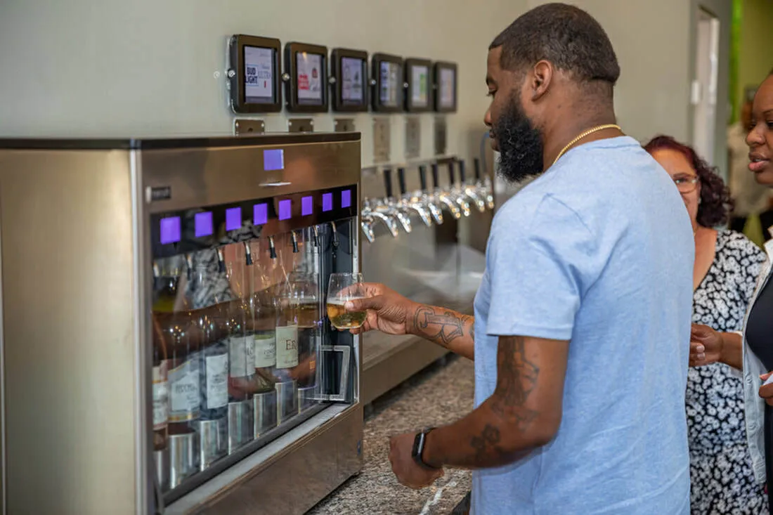 Modern self-serve beverage station with a variety of drink options, featuring a sleek stainless-steel dispenser and touch screen controls. Ideal for social gatherings.