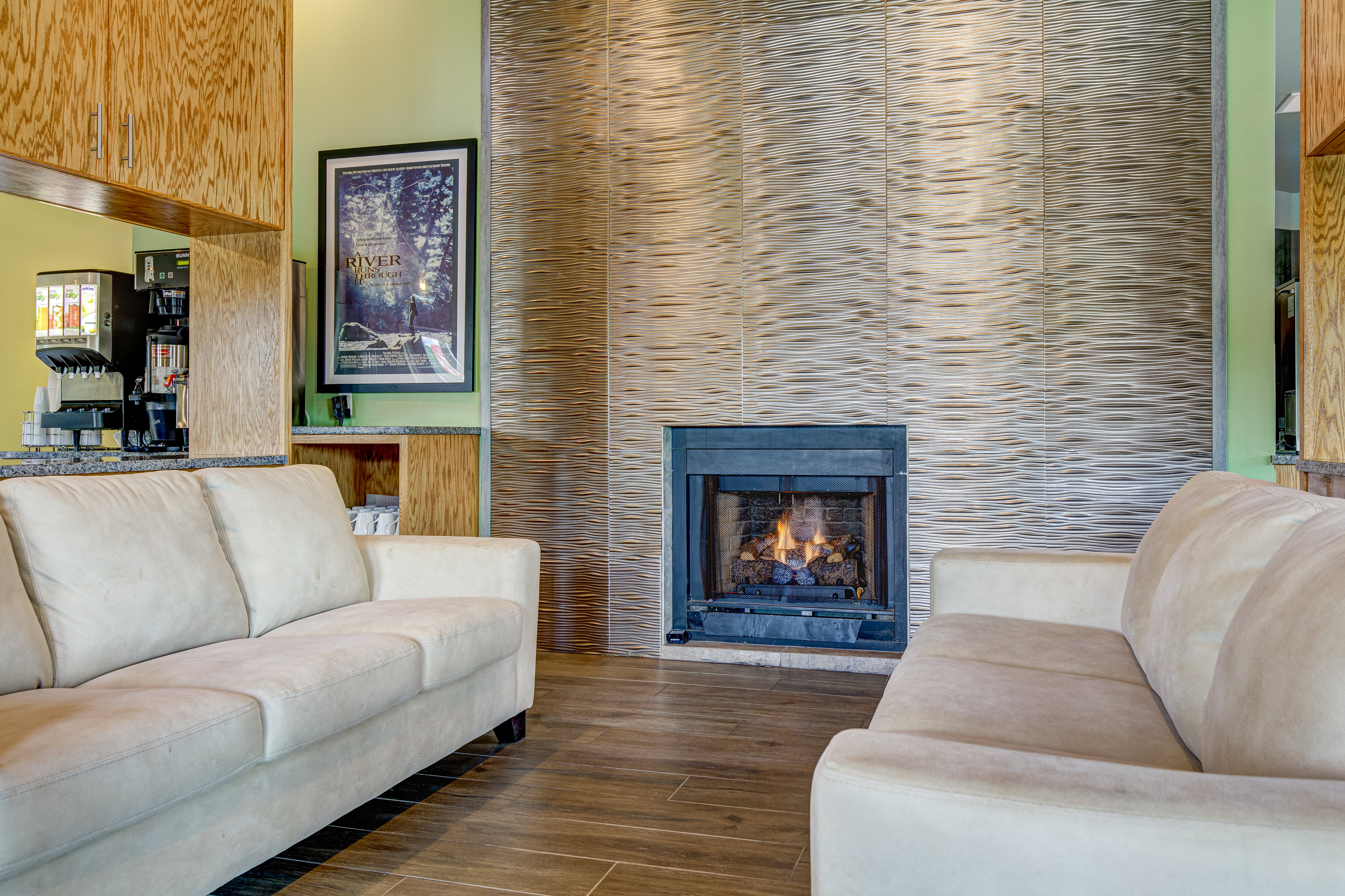 Cozy living area with soft beige sofas and a warm fireplace set against an elegant textured wall, perfect for relaxing evenings.