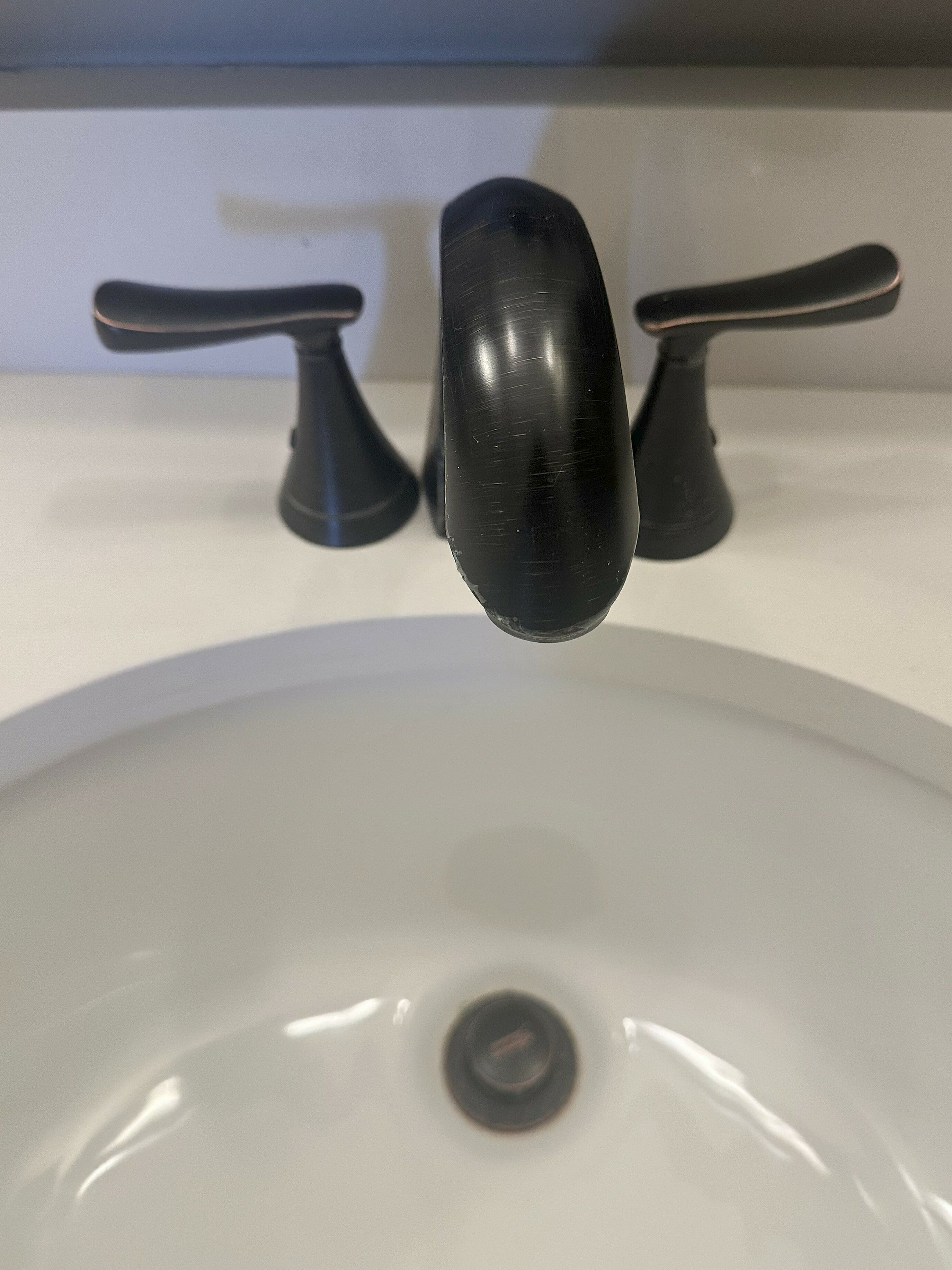 Elegant bathroom faucet with modern design, featuring sleek handles and a pristine white sink.