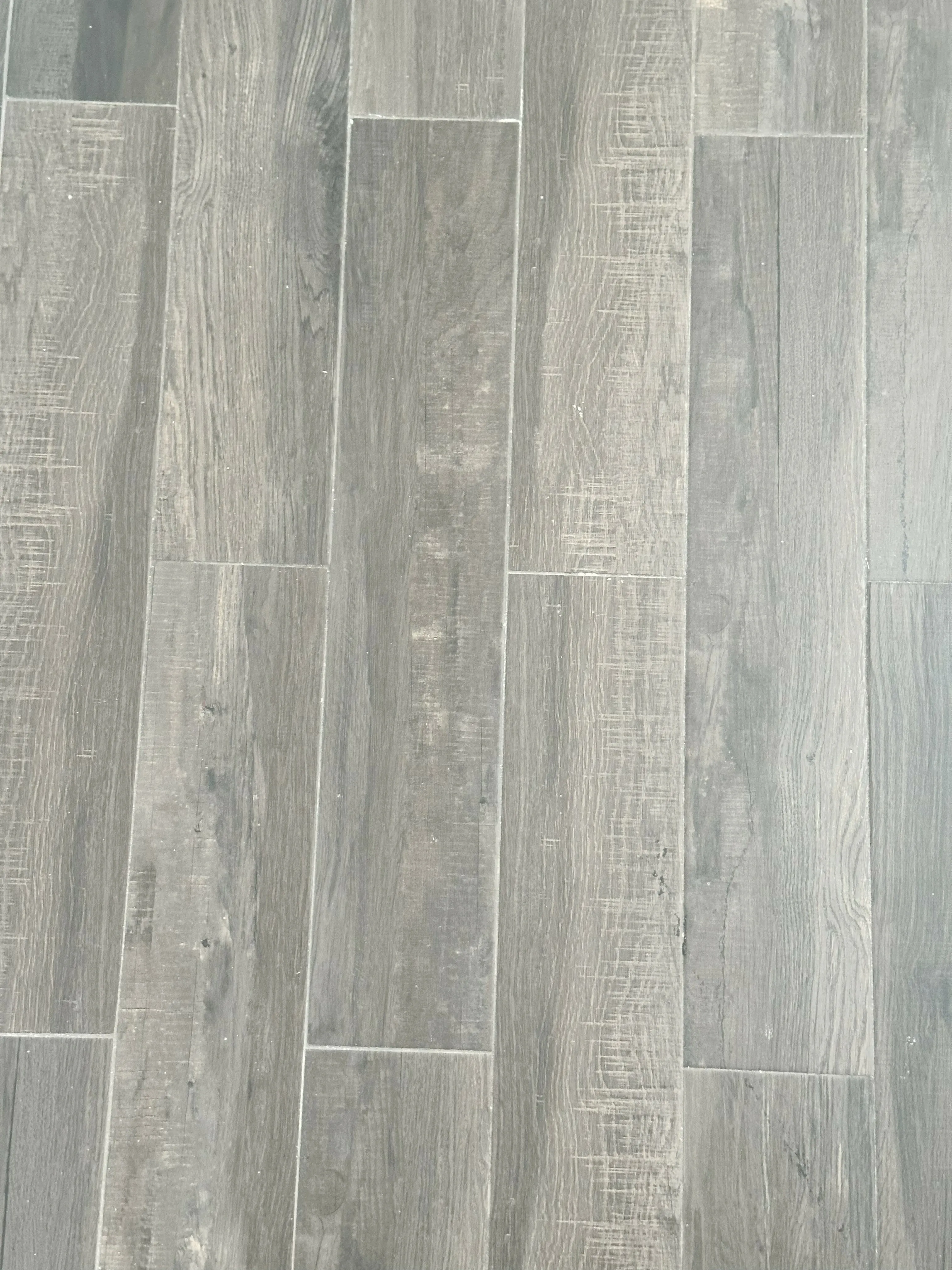 Sleek, modern grey hardwood flooring with a natural wood grain texture, perfect for adding elegance to any living space.