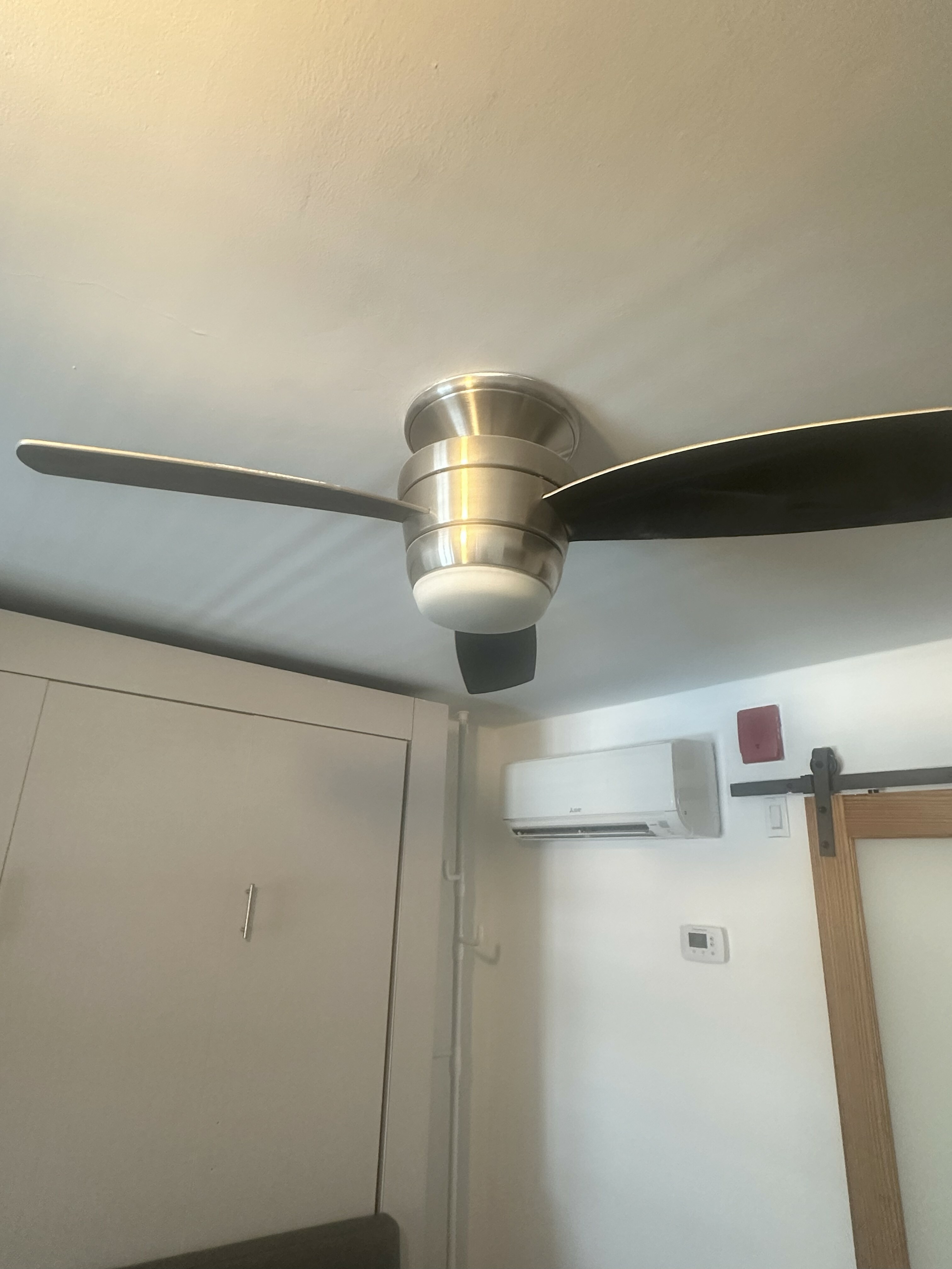Modern and sleek ceiling fan in a stylish room with contemporary air conditioning and elegant sliding door.