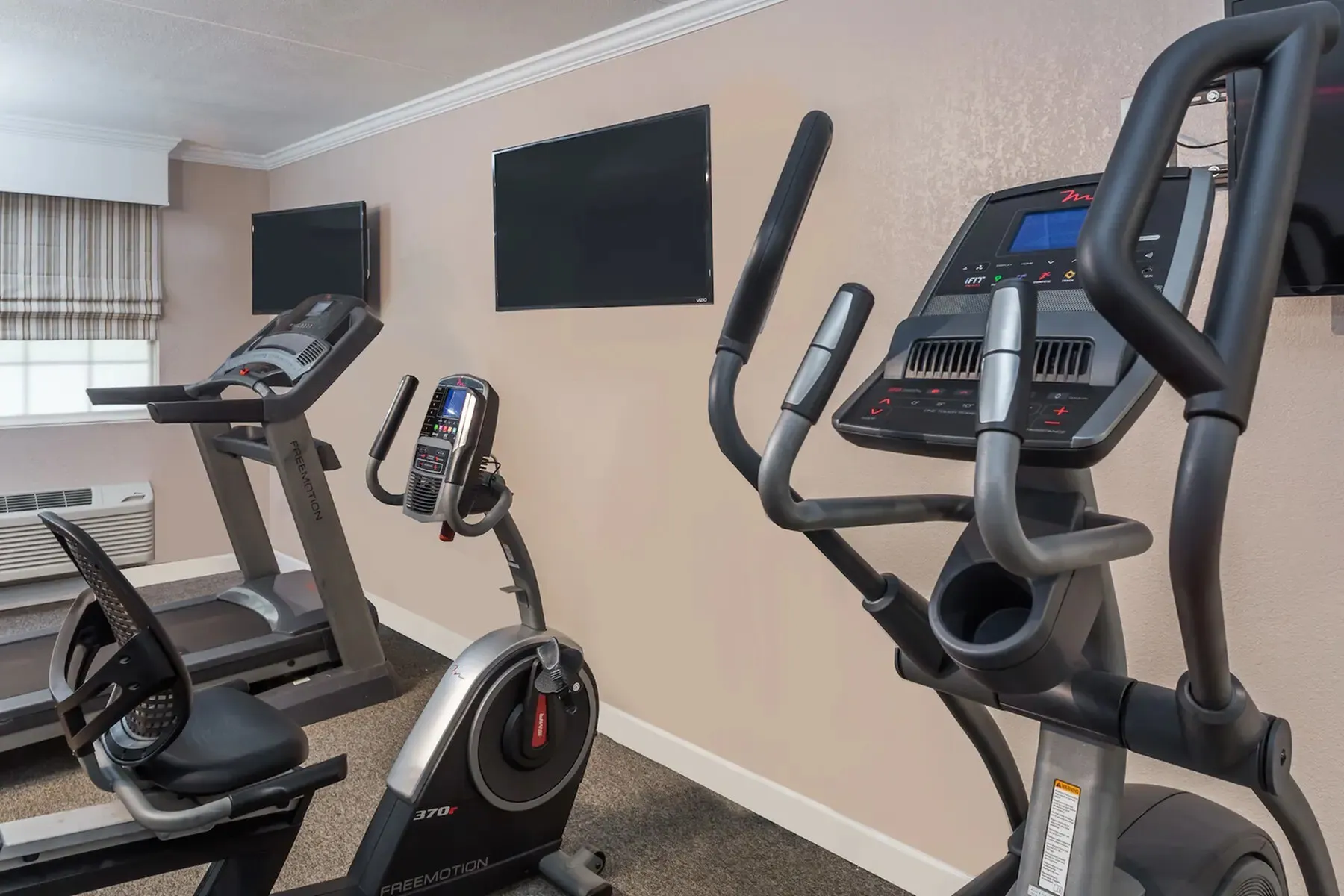 Modern fitness room with sleek cardio machines, including exercise bikes and ellipticals, perfect for an energizing workout.