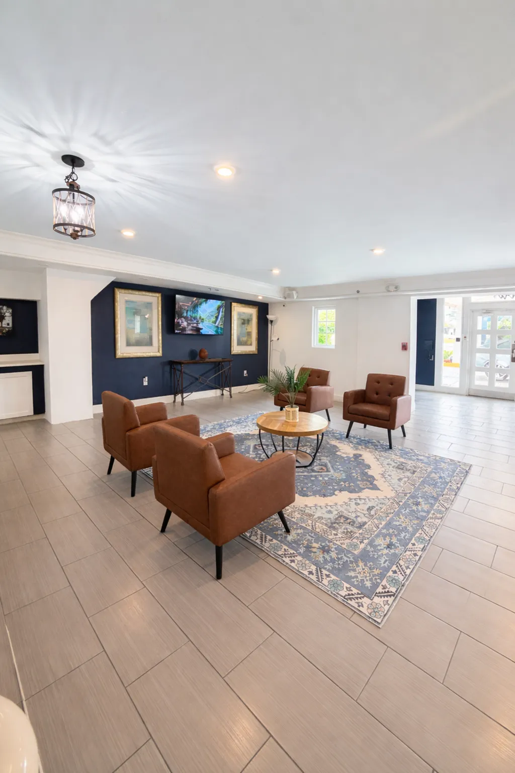 Inviting lounge area with modern leather chairs, elegant blue patterned rug, and tasteful wall art, creating a warm atmosphere.