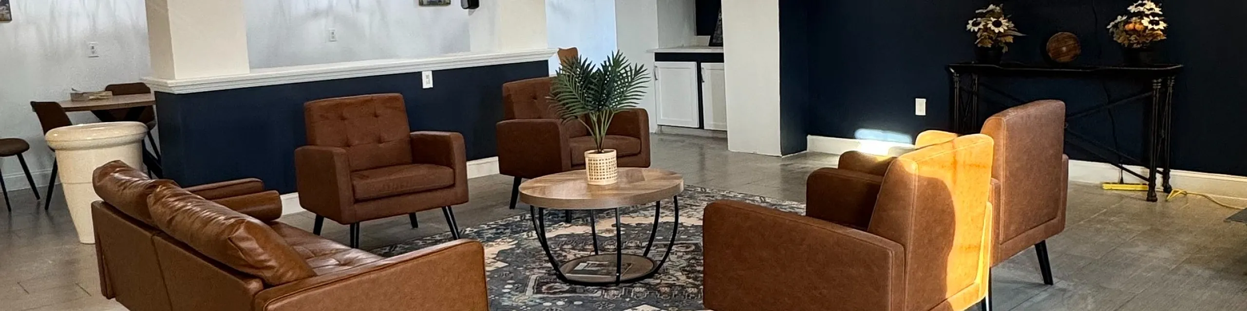 Elegant modern lounge featuring cozy brown sofas, stylish lighting, and a chic decorative rug, perfect for relaxation and socializing.