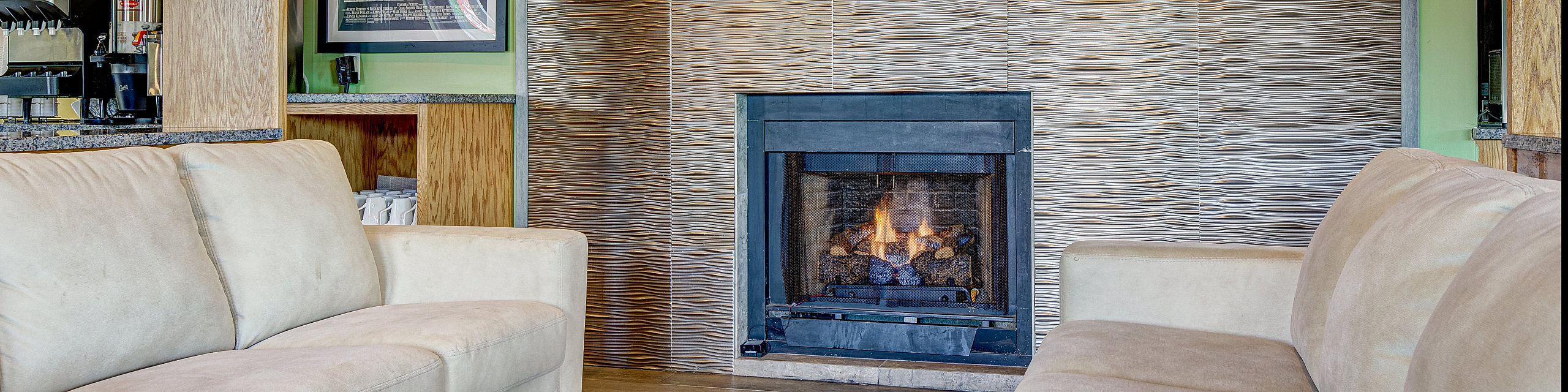 Cozy living area with chic modern fireplace, elegant beige sofas, and warm wooden accents, offering a relaxed ambiance.