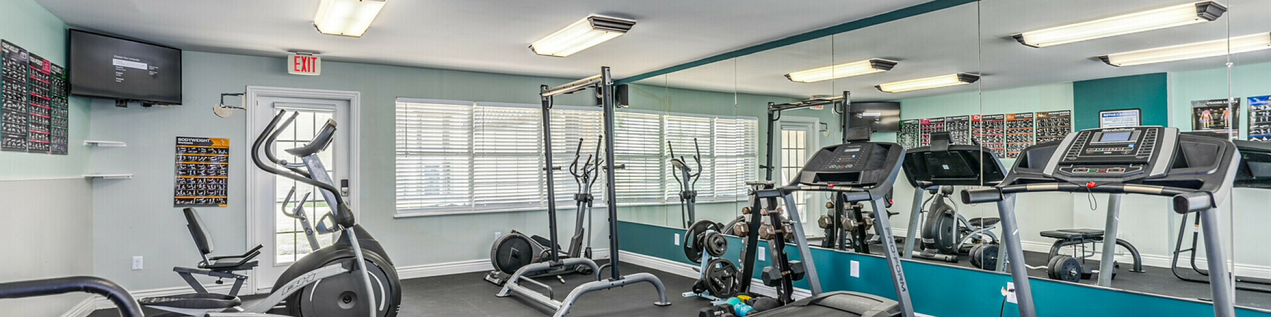 Bright and modern fitness center equipped with treadmills, weights, and an elliptical machine, ideal for a healthy lifestyle.