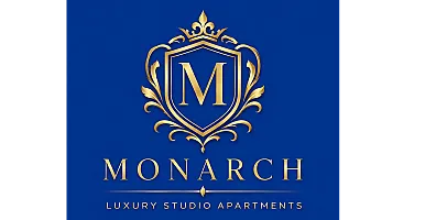 Elegant Monarch Luxury Studio Apartments logo with a golden emblem on a royal blue background, exuding sophistication and style.