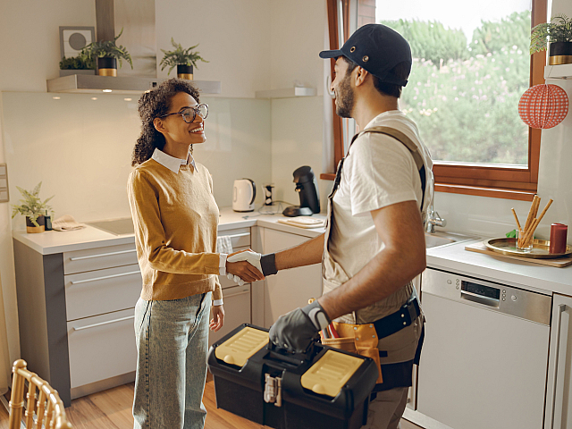 Bright kitchen scene with a professional handshake, highlighting trust and satisfaction in home service.