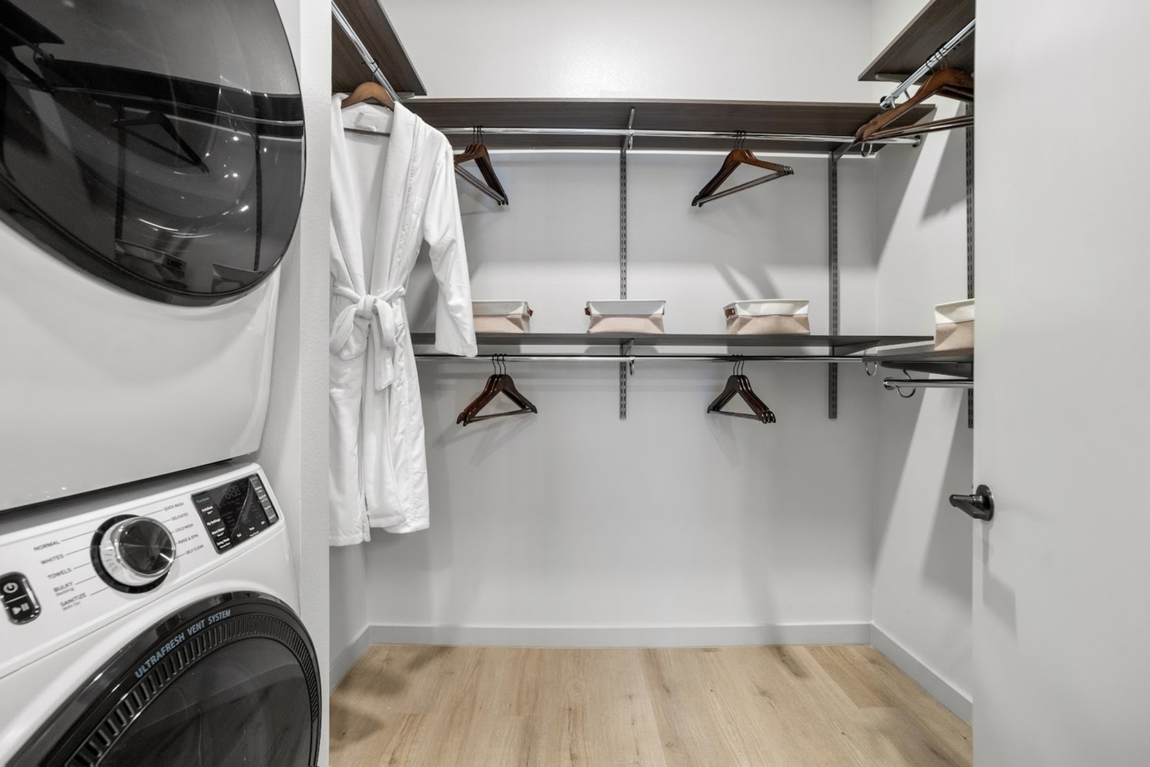 Spacious walk-in closet with adjustable shelving and full size washer and dryer
