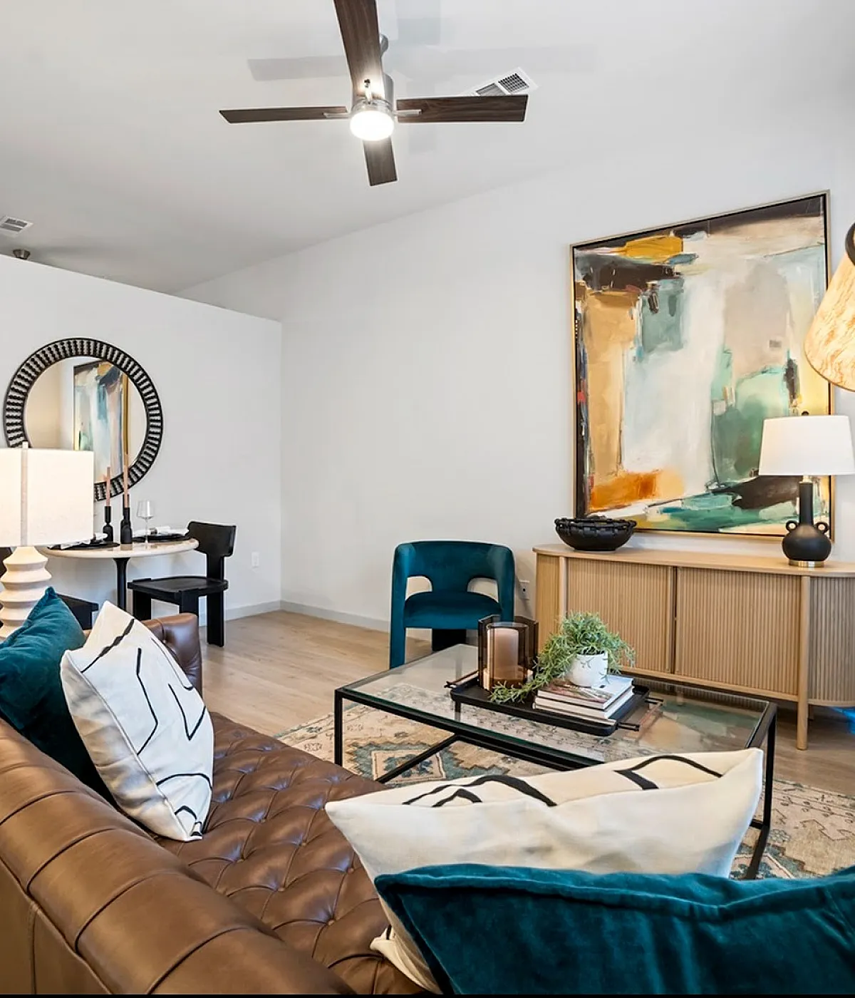 Chic and modern living room with stylish decor, featuring a cozy leather sofa, elegant abstract art, and a sleek glass coffee table.