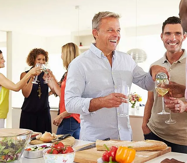 Vibrant social gathering in a modern kitchen, showcasing open space and natural light, perfect for entertaining.