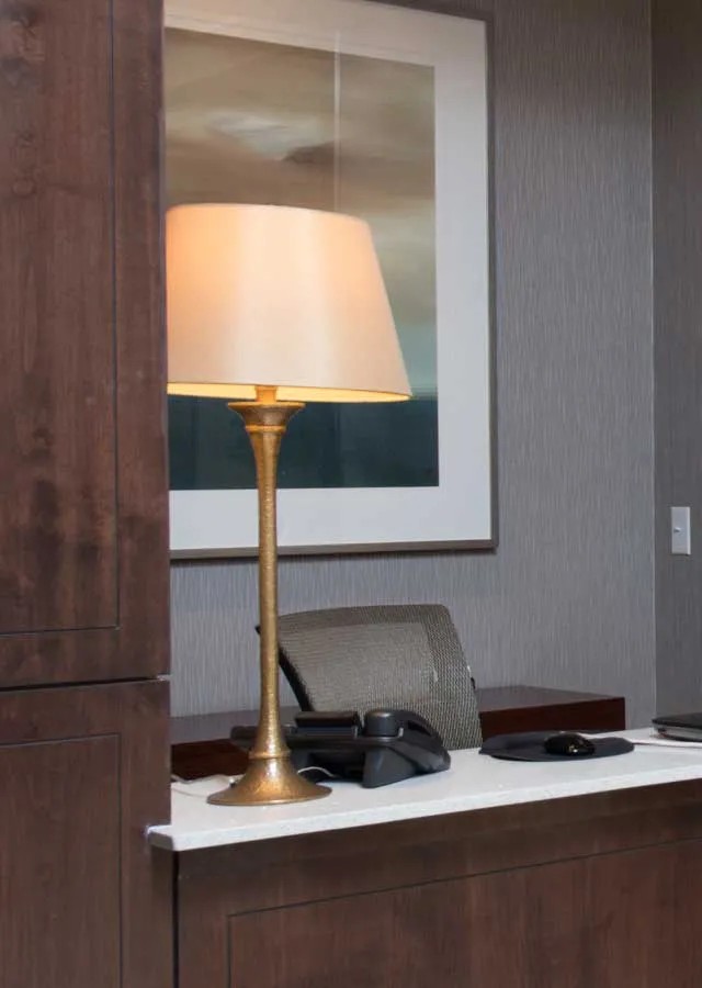Concierge area featuring a chic desk with a modern lamp and minimalist decor.