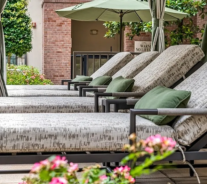 Luxurious pool area featuring a serene swimming pool, elegant cabana, and stylish lounging area surrounded by lush greenery.