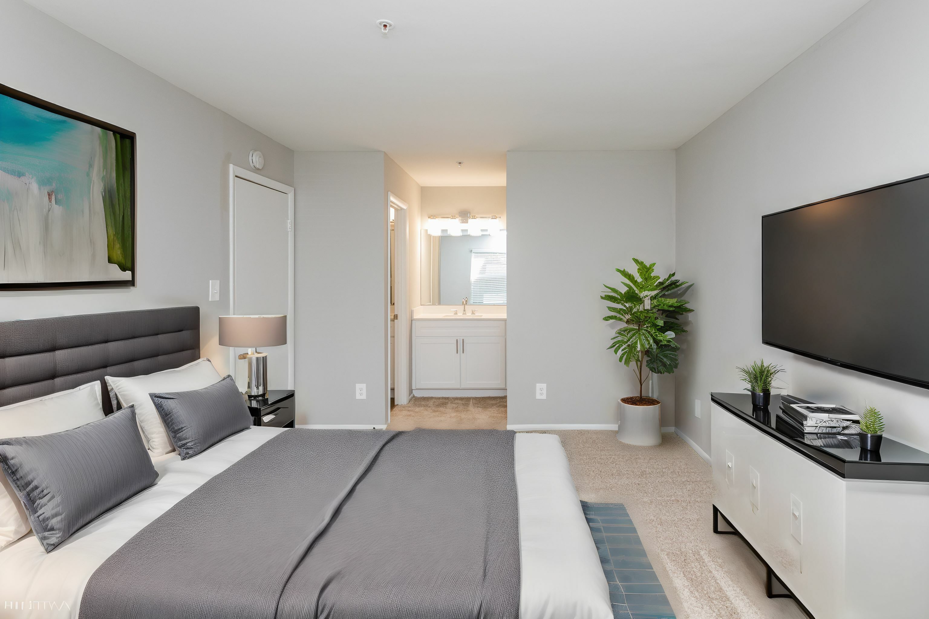 Bedroom with in-bedroom sink vanity and mirror and plush carpeting Countertops and White Cabinetry at Autumn Town Center Columbia apartments.
