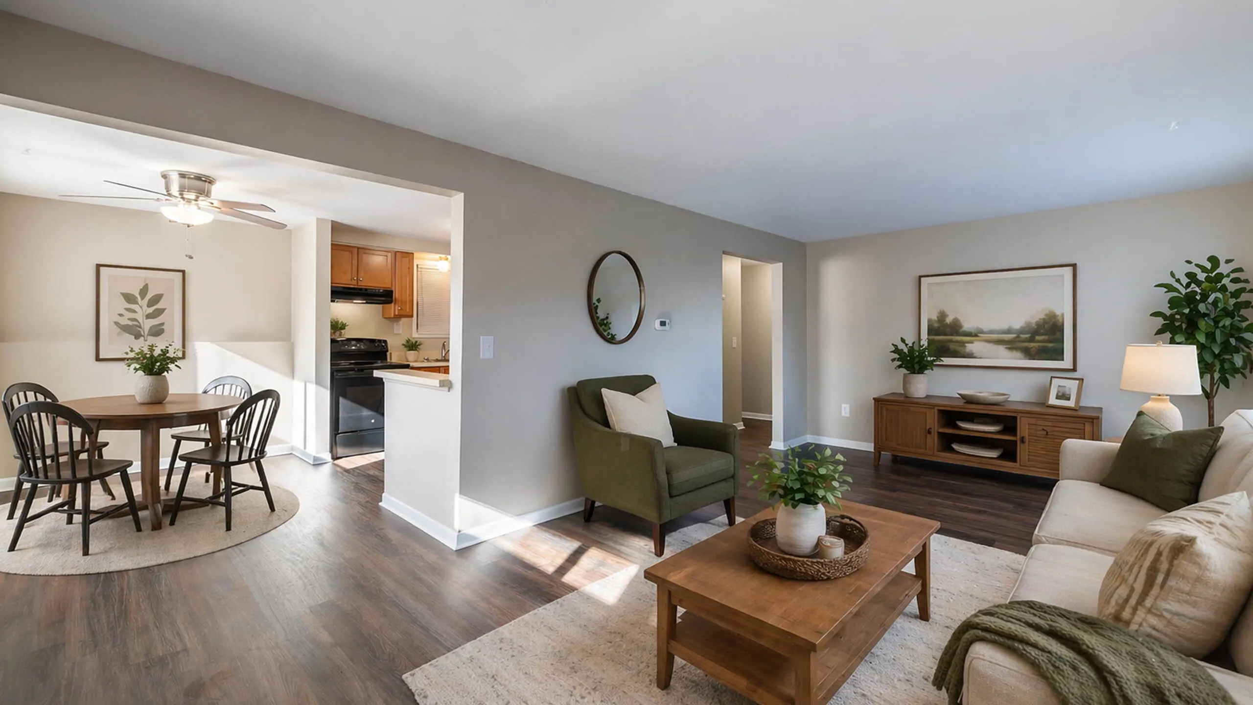 Inviting open-concept living room with elegant decor and hardwood floors, seamlessly connected to a modern dining area and kitchen.