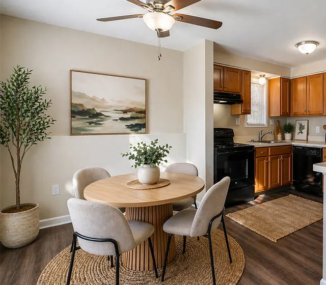 Charming apartment dining area with a cozy round table, modern kitchen, and elegant decor.