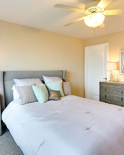 Inviting bedroom with plush pillows, stylish furniture, and warm lighting creating a cozy ambiance.