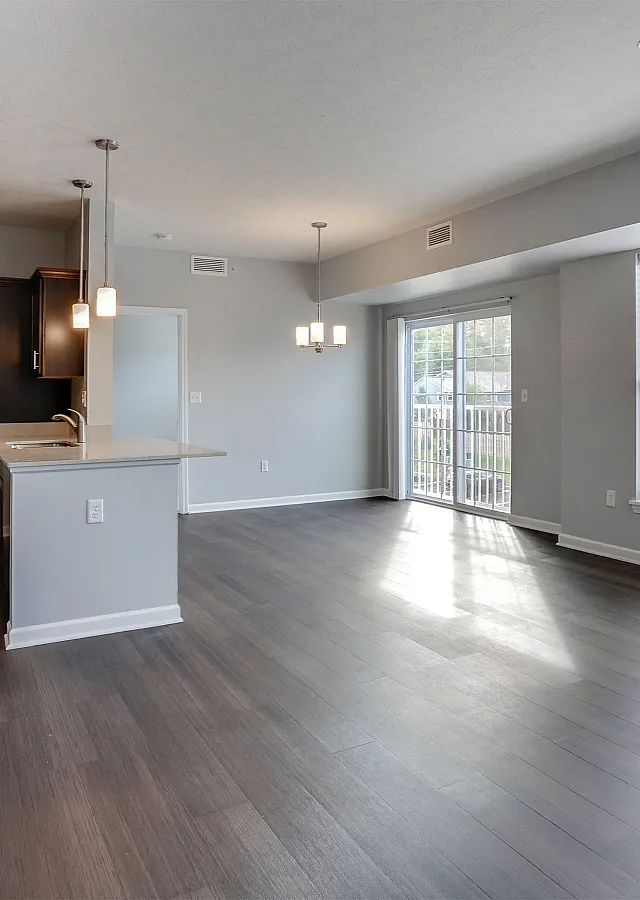 Bright, open-concept living space featuring sleek hardwood floors, modern kitchen with stainless steel appliances, and large windows with scenic views.