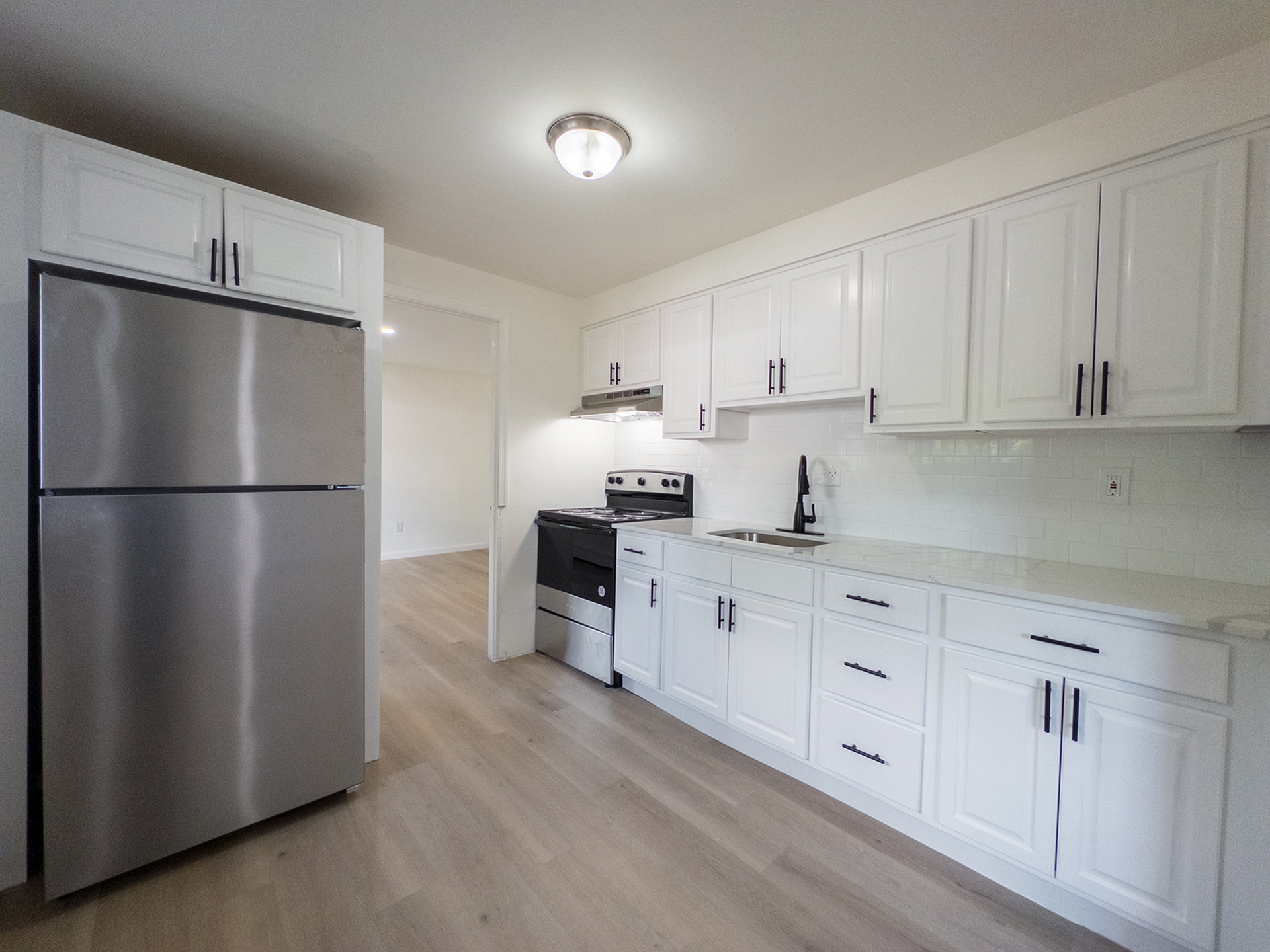 bright kitchen with white cabinets, stainless steel appliances