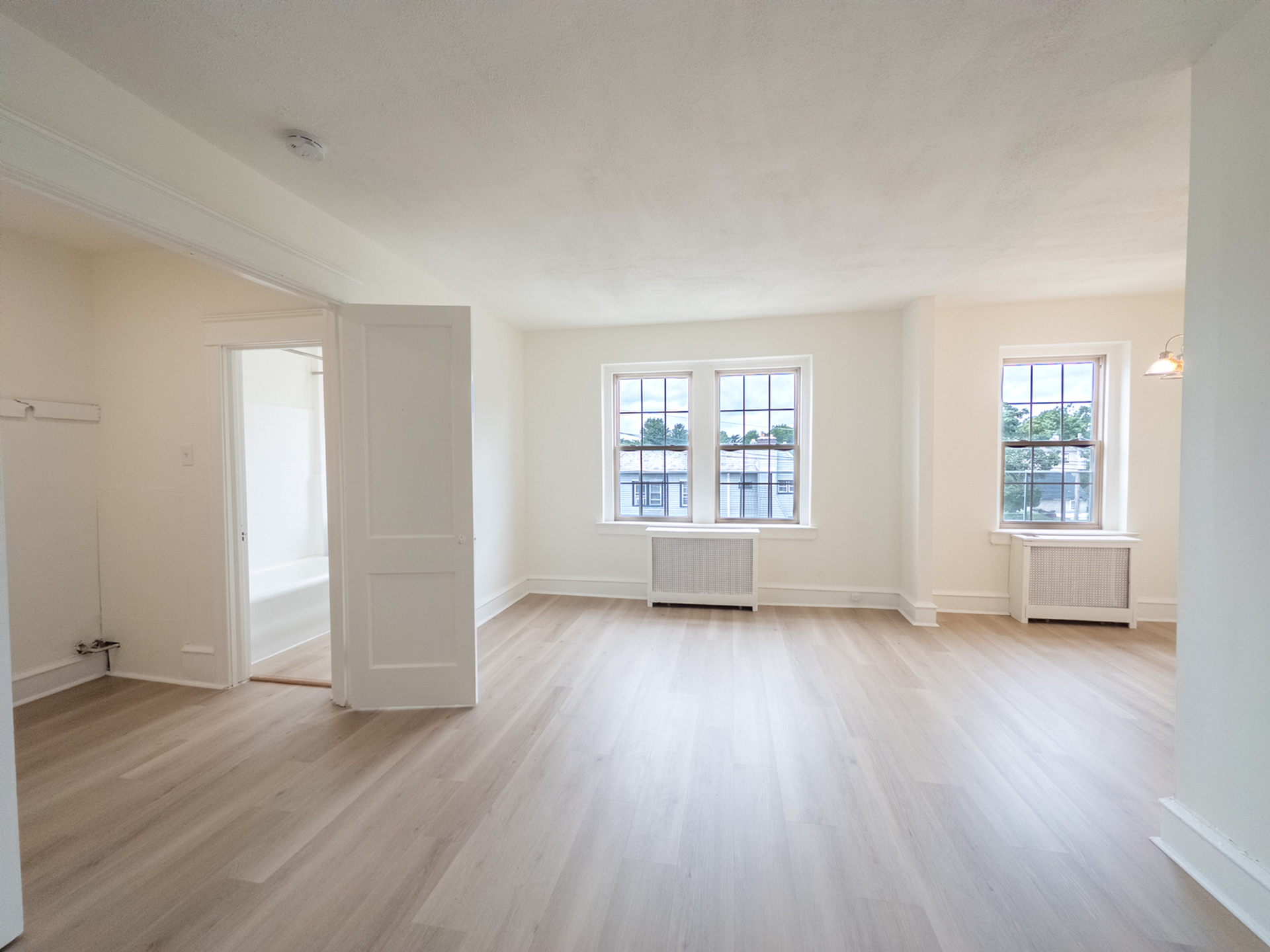 studio apartment with big windows, natural light, wood flooring