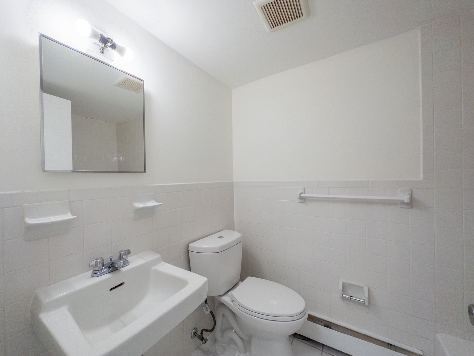 bathroom with tiled wall, energy efficient toilet