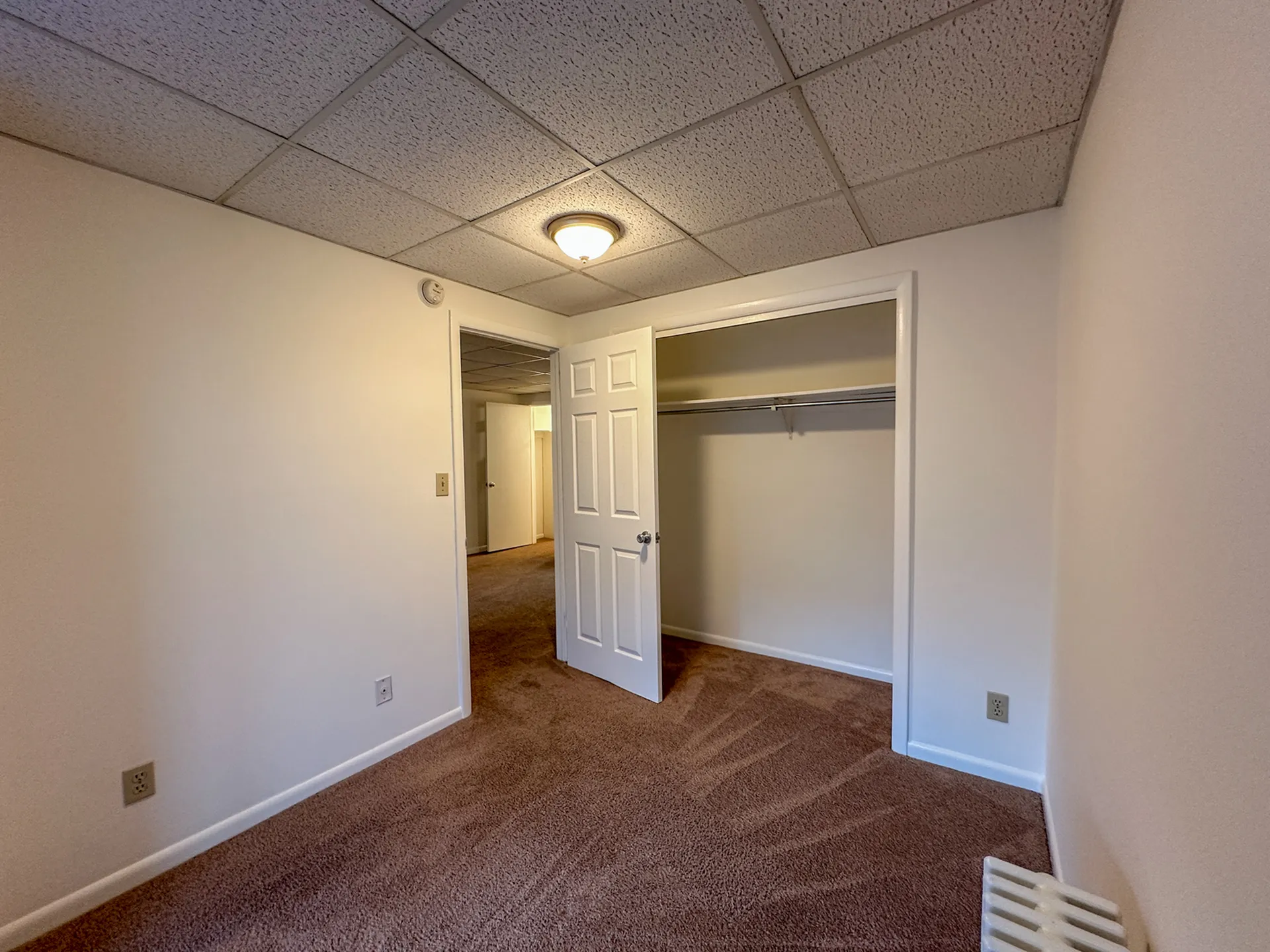 Inviting bedroom with plush carpeting, spacious closet, and warm ambient lighting.