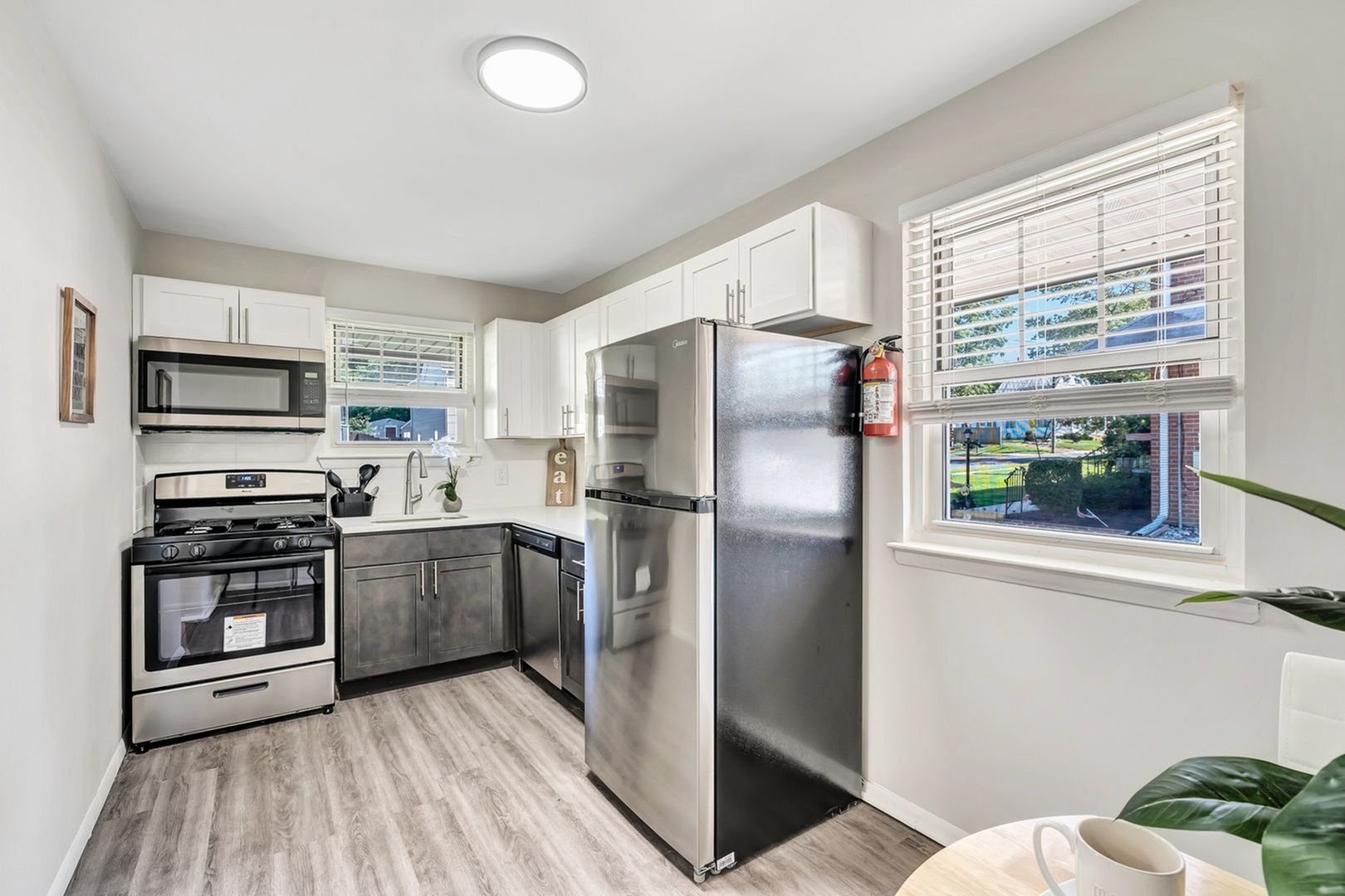 Bright, modern kitchen featuring stainless steel appliances, elegant cabinetry, and large windows for natural light.