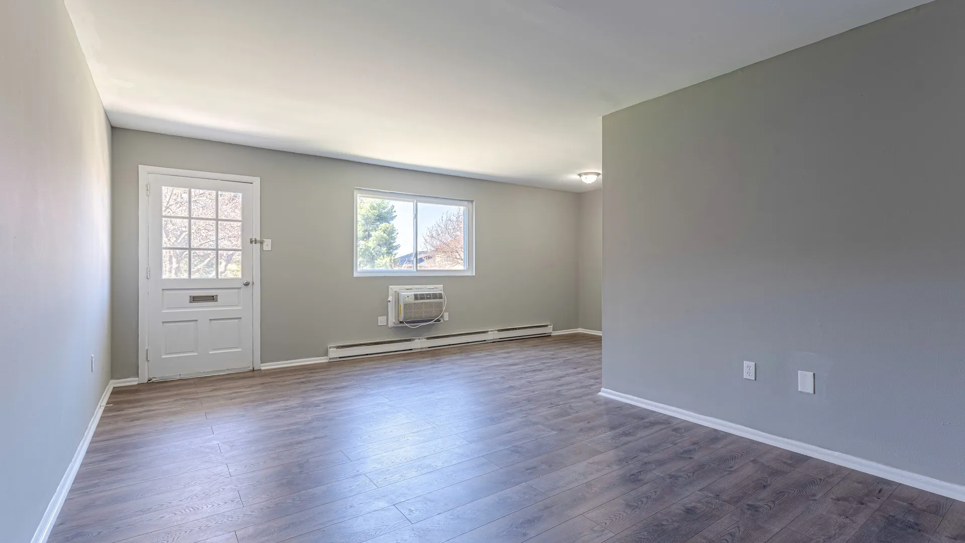 Well-lit apartment with wood panel floors