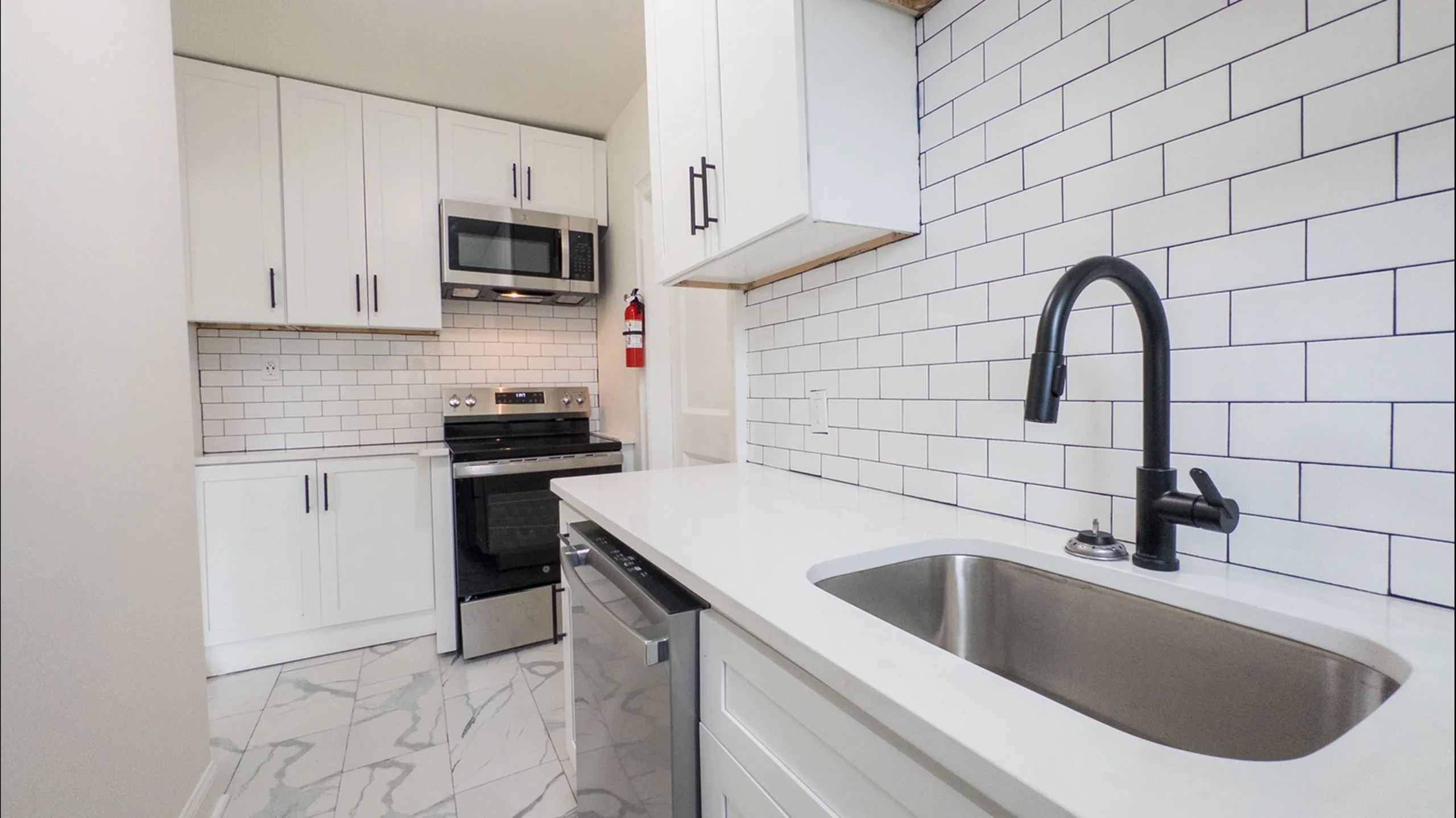 renovated kitchen with wooden cabinets and white fridge and oven/stove, apartment kitchen, black sink faucet, lots of cabinets, dishwasher, granite counters, white tile backsplash