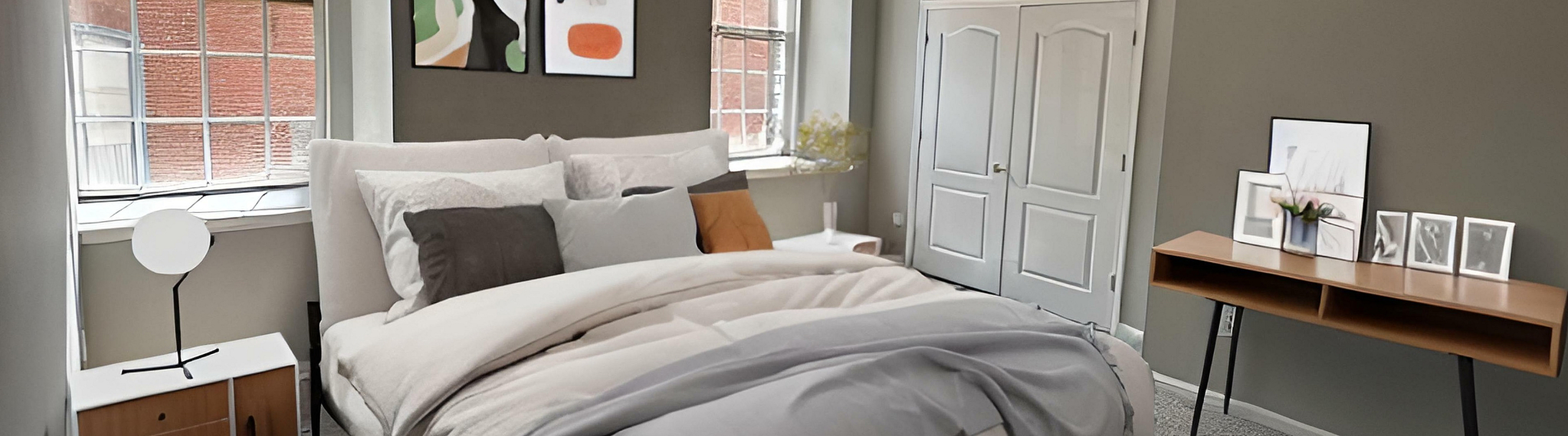Chic urban bedroom boasting large windows, elegant decor, and stylish industrial accents.