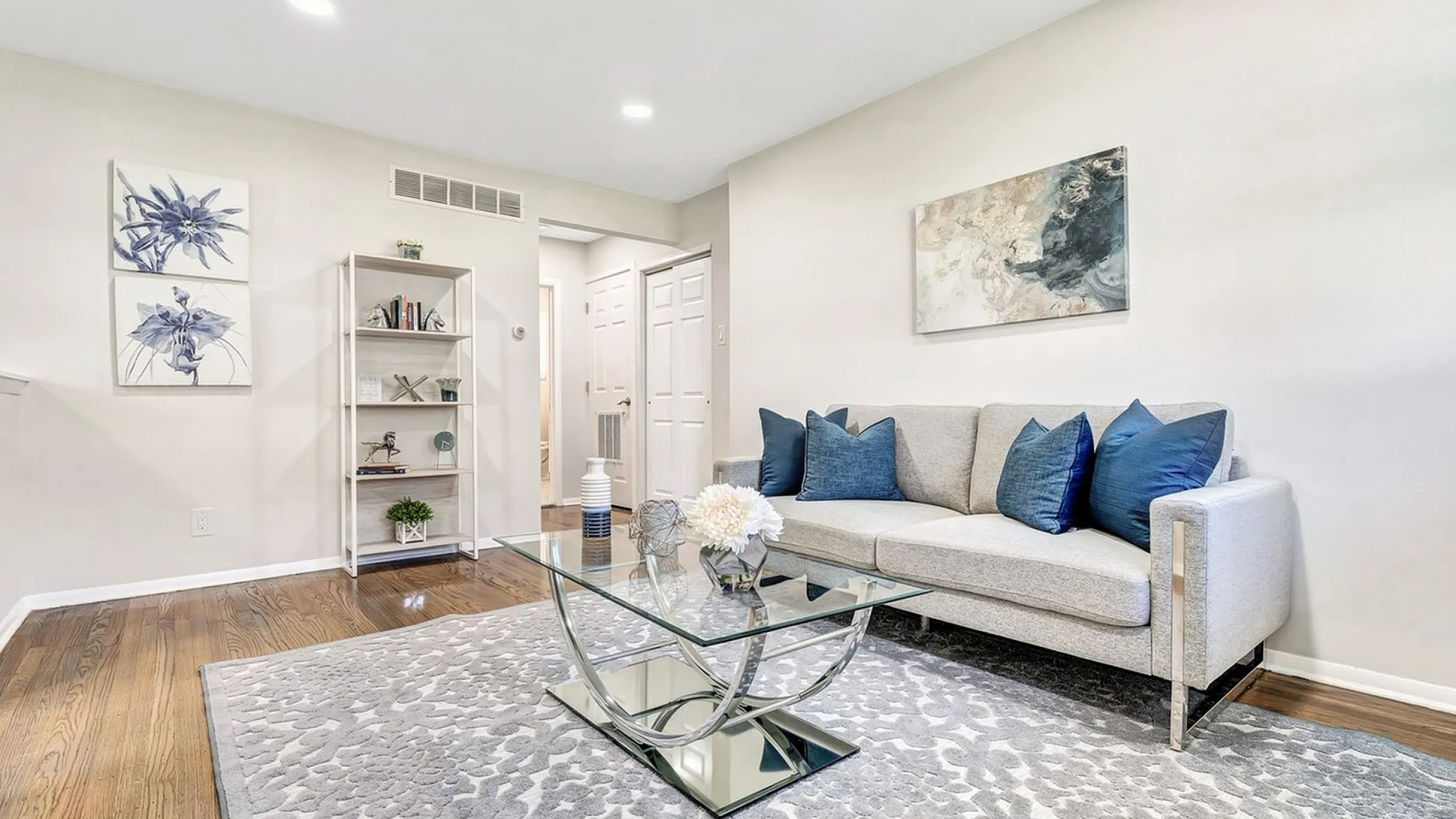 Contemporary living room with elegant sofa, glass coffee table, and chic d&eacute;cor, featuring a serene ambiance and modern style.