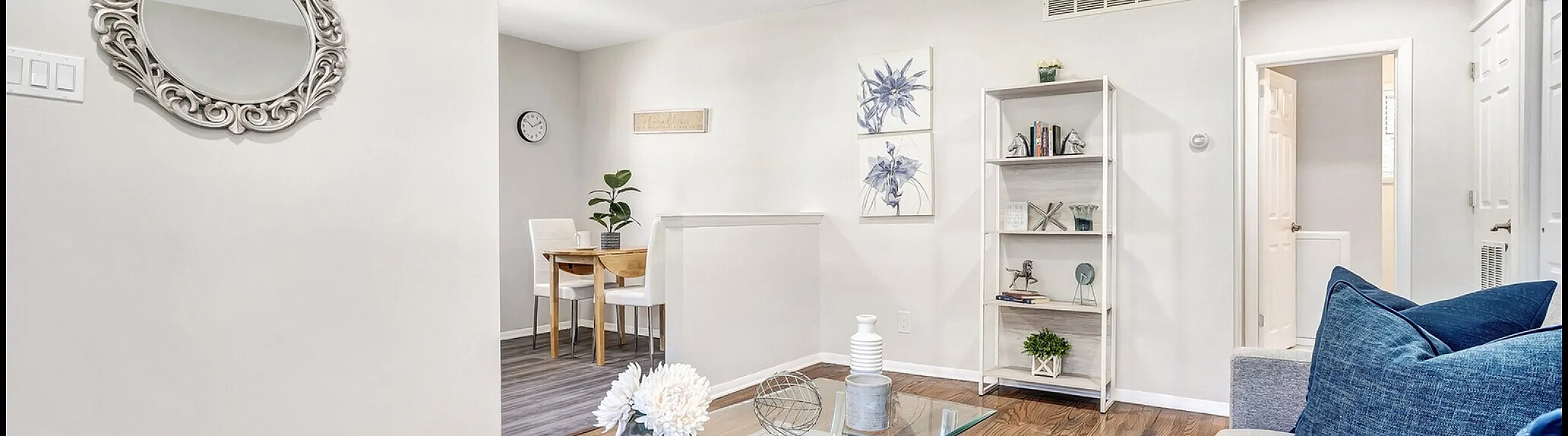Elegant living area with modern decor, featuring a plush sofa, stylish glass coffee table, and cozy dining space.