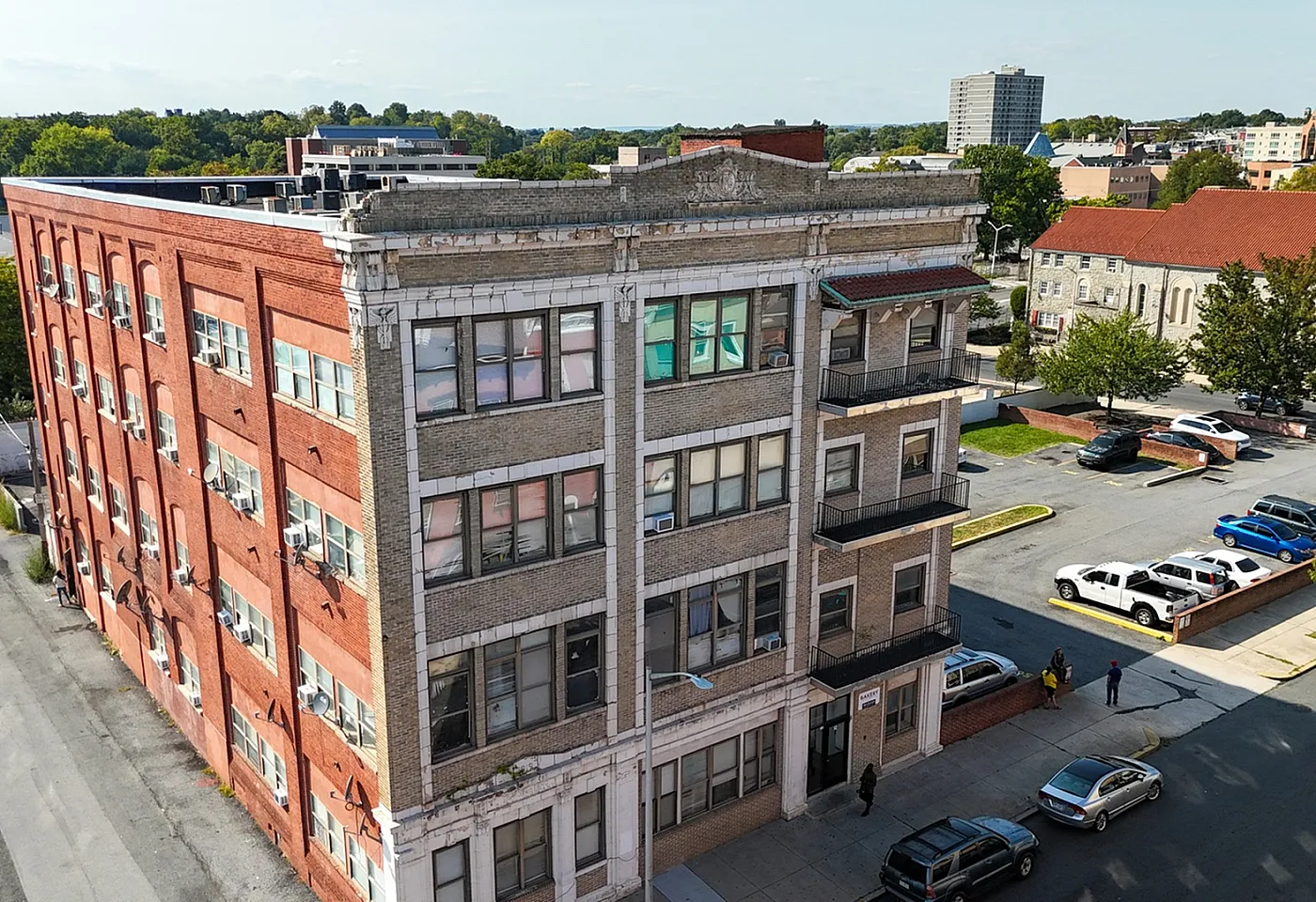 Charming historic brick building with large windows in a vibrant urban neighborhood, perfect for modern city living.
