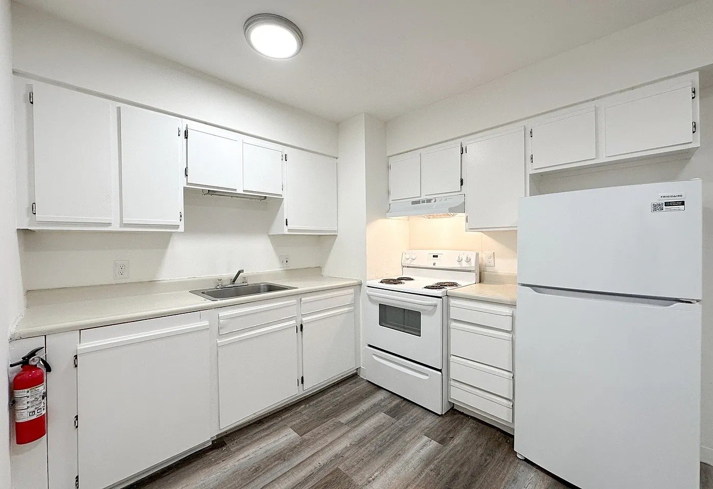Bright and modern kitchen with sleek white cabinets, spacious countertops, and stainless steel appliances.