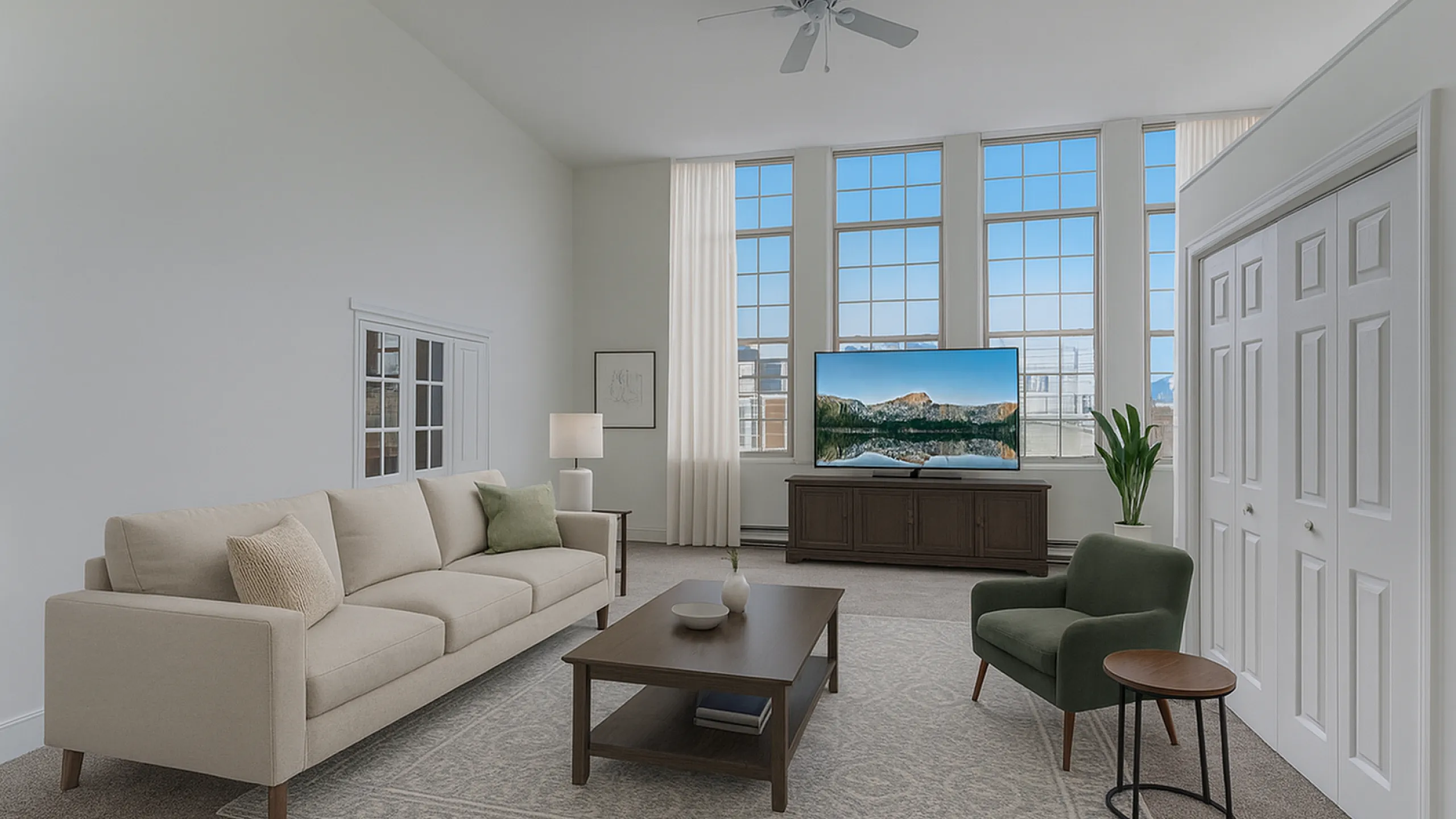 Elegant living room with high ceilings, featuring a plush beige sofa, modern coffee table, and large windows offering abundant natural light.