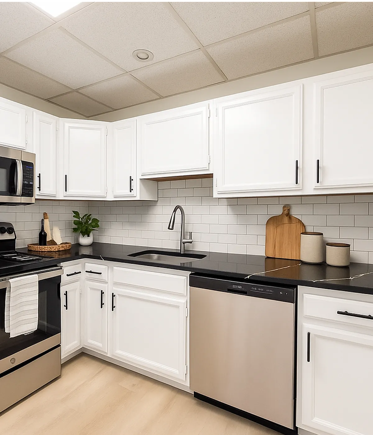 Modern kitchen with sleek stainless steel appliances, elegant black countertops, and crisp white cabinetry.