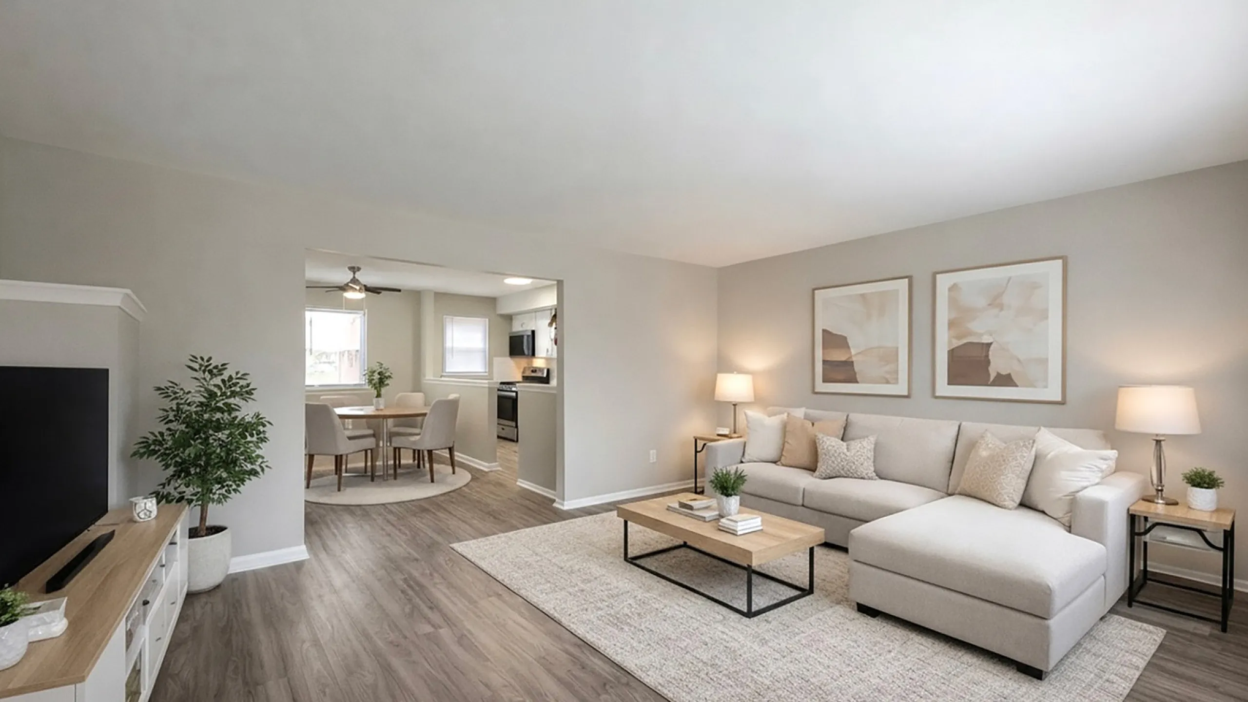 Stylish open-plan living room with cozy sectional sofa, modern dining area, and sleek kitchen, illuminated by natural light.