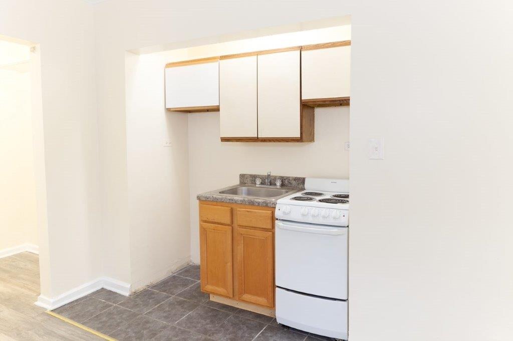 Apartment 107 Kitchen with white cabinets and a wooden sink base.