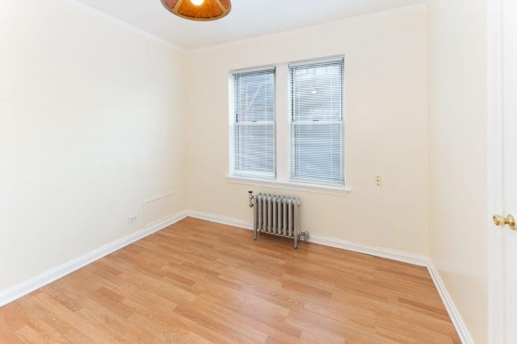 06 tier bedroom with wood floors and a double window.