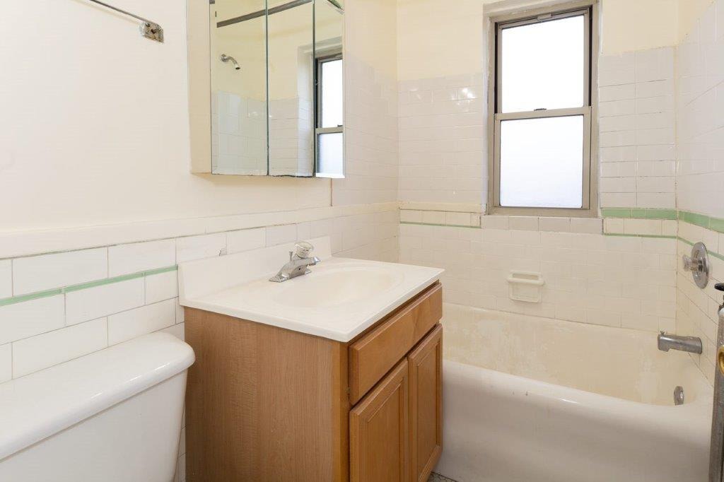 Bathroom with wooden vanity and tub.