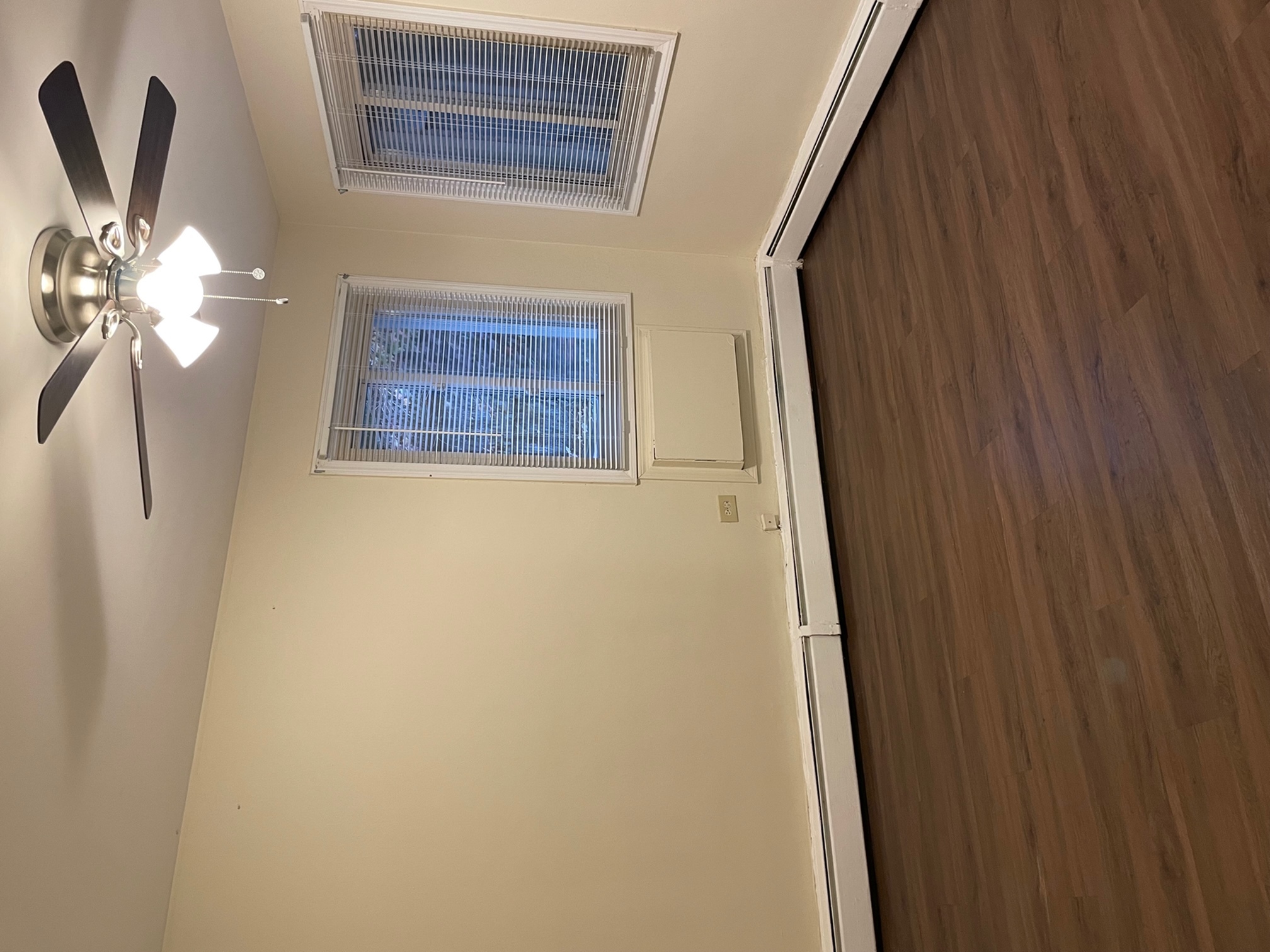 Bedroom with corner window and a ceiling fan.