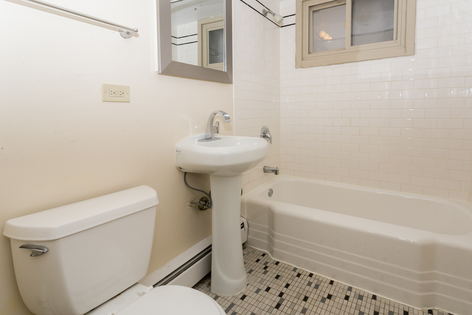 Bathroom fetureing ceramic tile floor and tub surround and pedestal sink.
