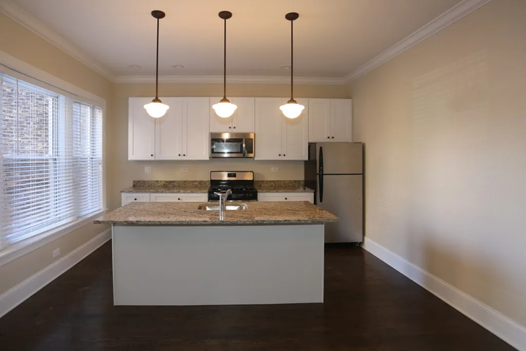 A kitchen with white cabinets, stainless steel appliance and an island