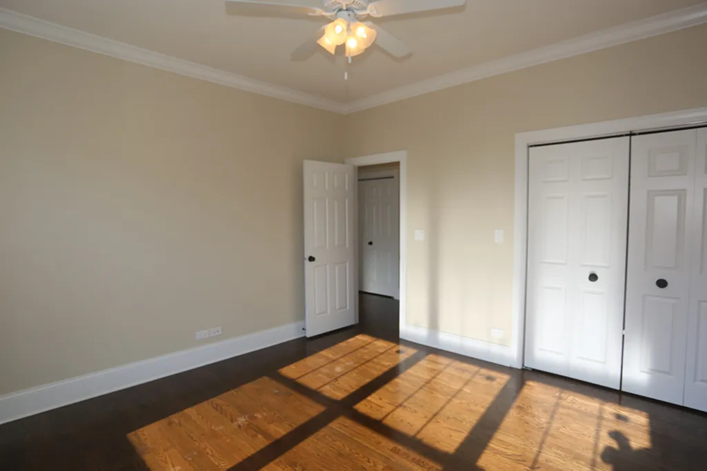 A bedroom with hardwood floors and great closet space.