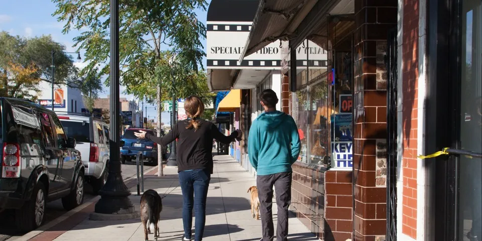 Two people walking down the sidewalk shopping in Andersonville on a fall day.