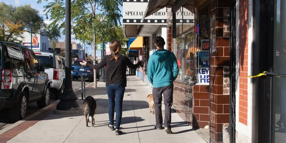 Two people walking down the sidewalk shopping in Andersonville on a fall day.