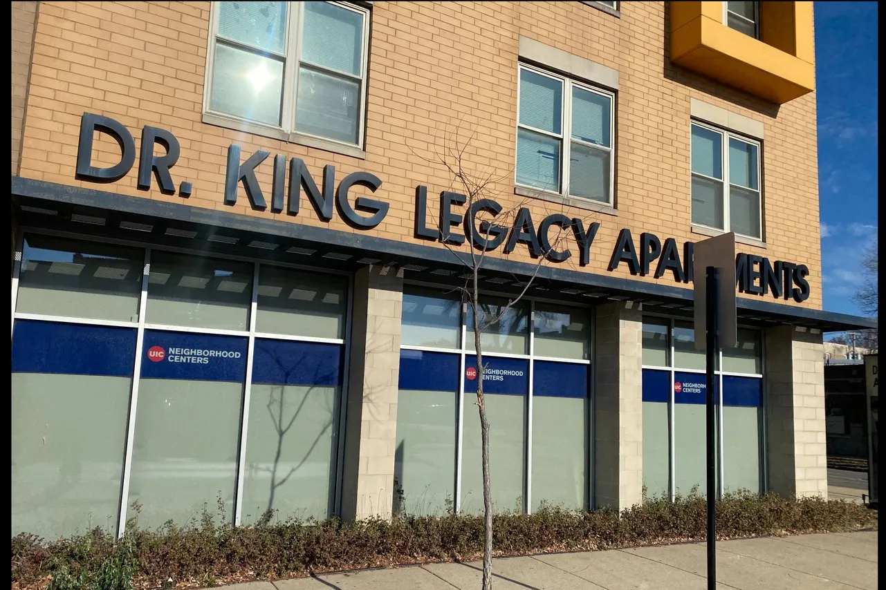 Exterior of Doctor King Legacy Apartments a forty six unit income restricted yellow brick building with glass storefronts on the first floor in Lawndale.